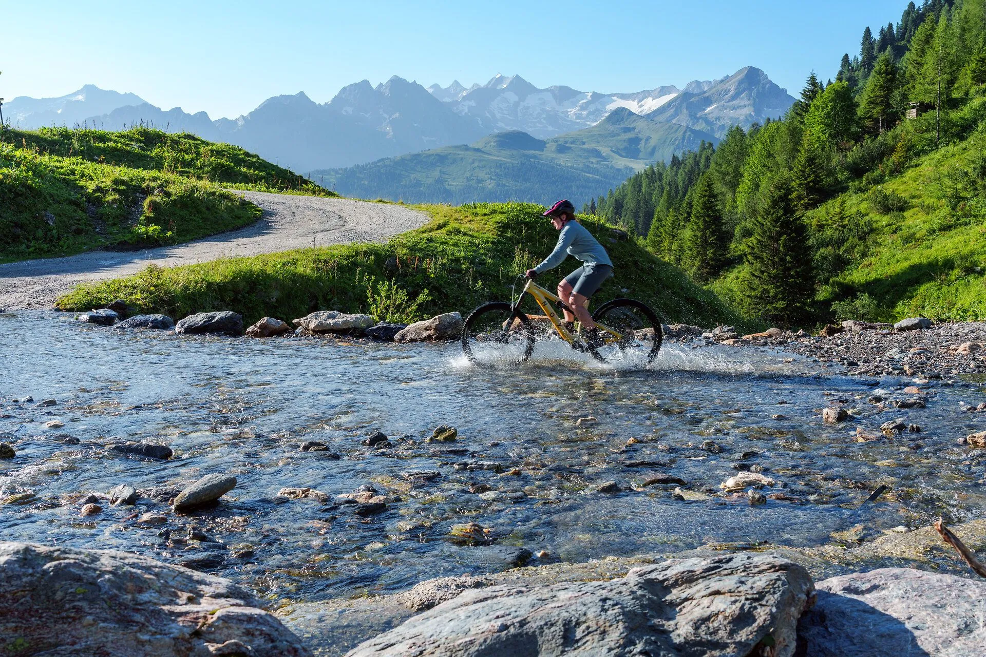 Mountainbiker rijdt door een beek in de bergen