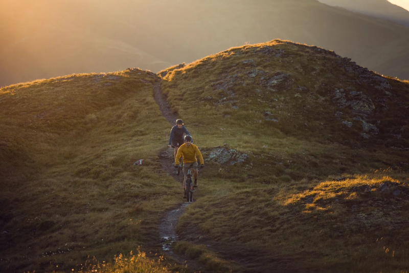 Mountainbikers op een bergpad bij zonsondergang