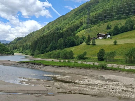 Brede kiezelbedding van een bergbeek in een groen dal met boerderijen – Rondje Stausee Gmünd en de stuwdam van Gerlos, Gerlos
