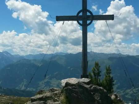 Houten topkruis op een rotsige top met wolkenlucht – Karspitze vanuit Gerlosberg, Gerlos
