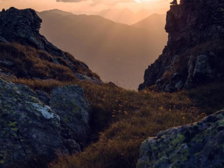 Rotswand in tegenlicht met de zon boven de bergkam – Isskogel en Kreuzjoch (2.558 m), Gerlos